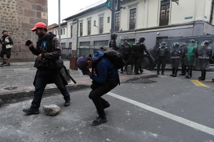 Periodistas agredidos por policías buscan asistencia de paramédicos durante una jornada de protesta
