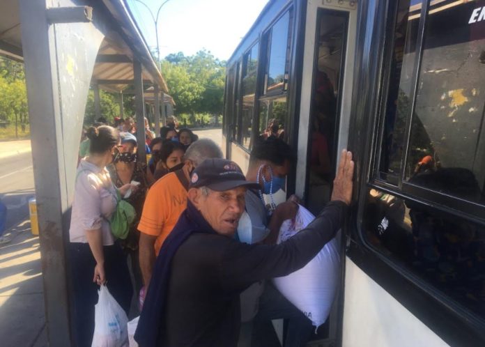 Mientras los autobuses pasan más de media hora detenidos en los puntos de control las personas se quejan por la falta de unidades y deben hacer largas colas para regresar a sus destinos. Foto: Joanne González.