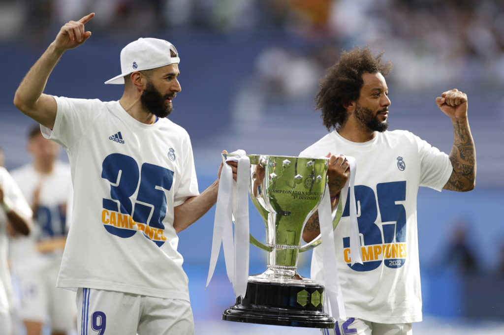 30/04/2022.- Los jugadores del Real Madrid Karim Benzemá y Marcelo Vieira celebran el título de Liga, al término del partido de Liga en Primera División ante el RCD Espanyol que han disputado este sábado en el estadio Santiago Bernabéu, en Madrid. EFE/Mariscal