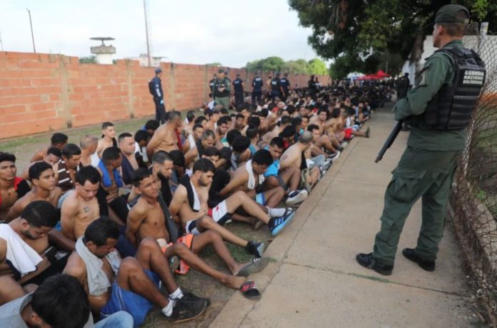 Presos sentados y formados en el patio, durante el operativo de intervención al penal de Vista Hermosa, en Ciudad Bolívar (Venezuela). MINISTERIO DEL INTERIOR (EFE)